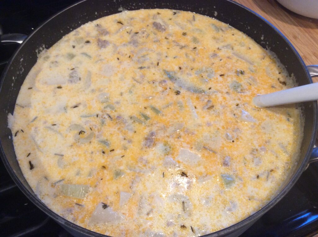 Potato and Leek Soup with Sausage in a stock pot with ladle.