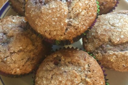 Black raspberry muffins with sugar-crystal topping on a plate