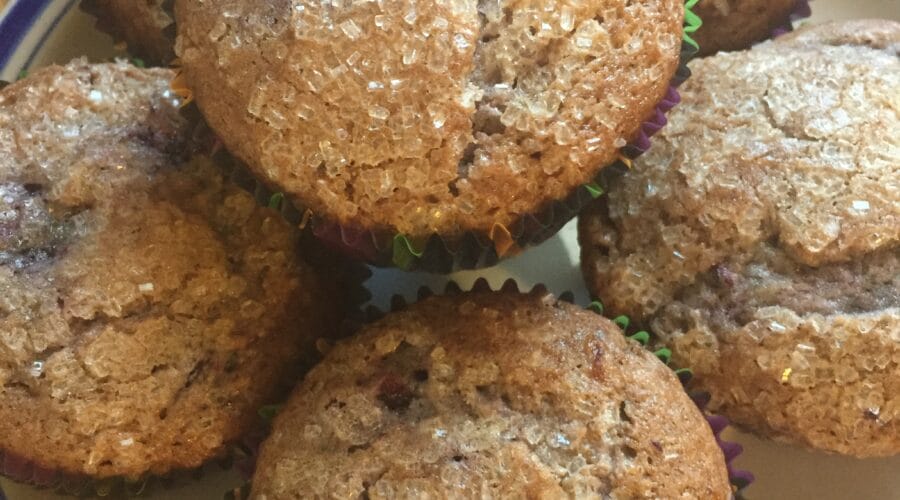 Black raspberry muffins with sugar-crystal topping on a plate