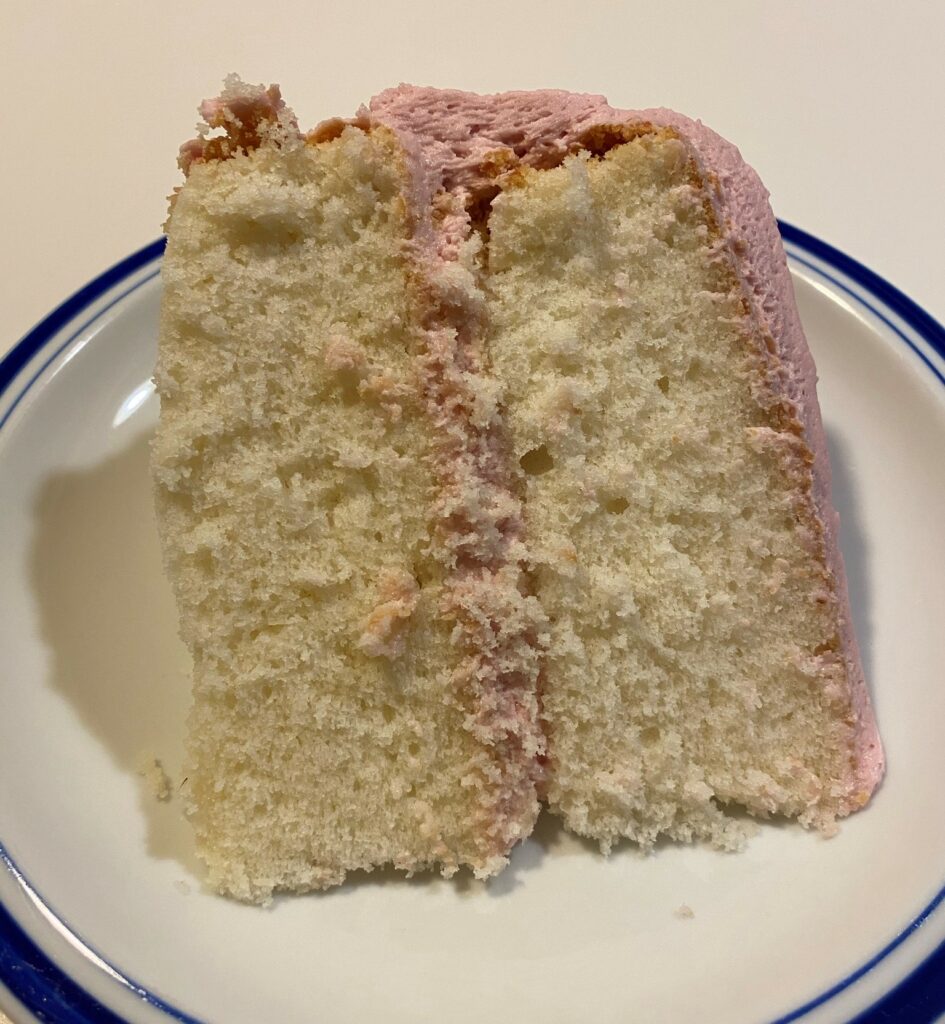 A slice of White Velvet Cake, on a plate.