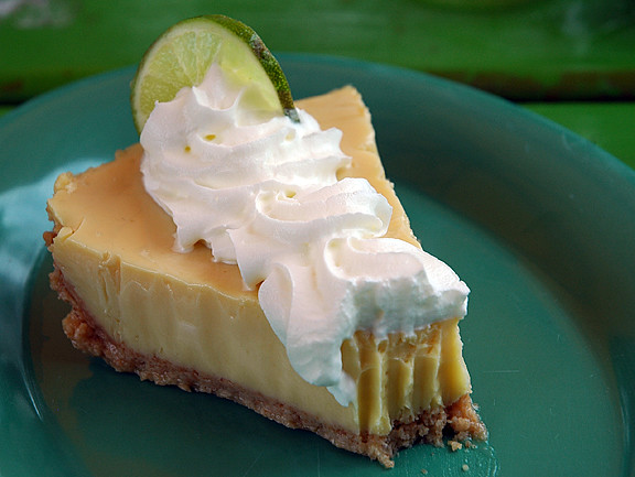 A slice of Tangy Key Lime pie with one bite taken out.