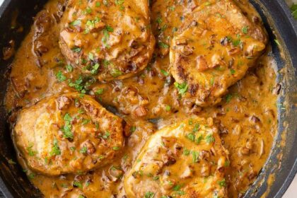Smothered baked pork chops in cast iron skillet