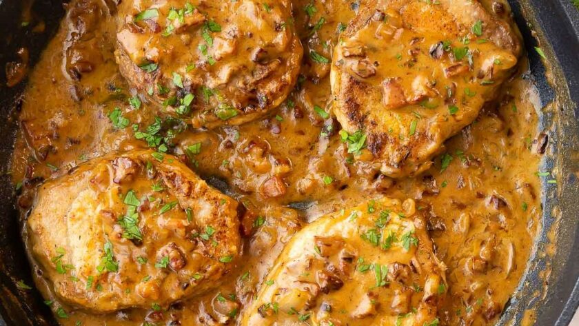 Smothered baked pork chops in cast iron skillet