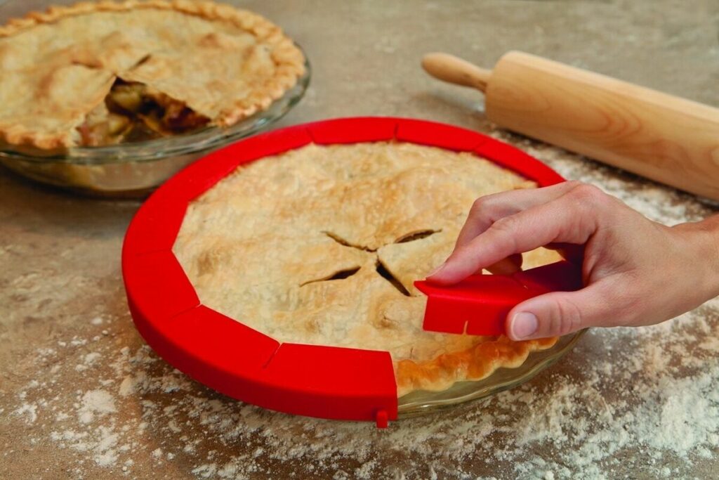 Red silicone pie shield wrapped around a pie.