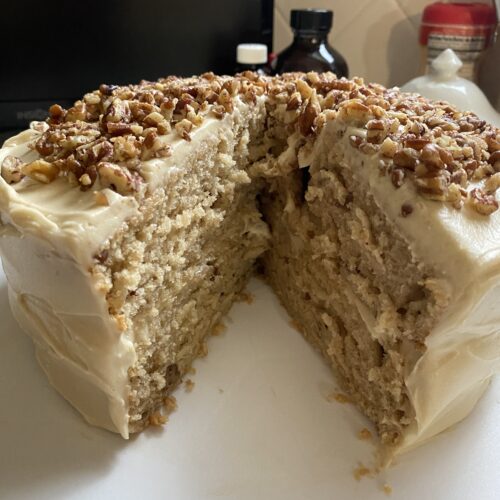 Butter Pecan Cake Recipe cake on a tray with slice removed.