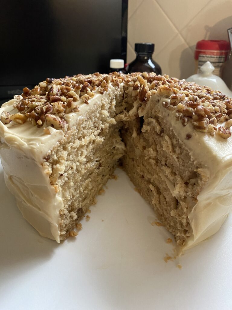 Butter Pecan Cake Recipe cake on a tray with slice removed.