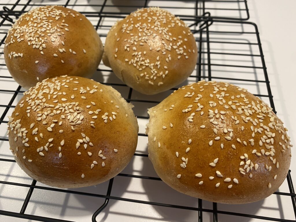 Sesame Seed Buns Four Homemade Sesame Seed Buns on a cooling rack